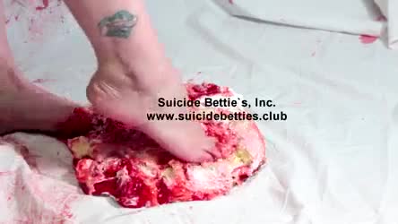 Cute feet crushing a strawberry cake